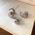 Detailed view of three minimalist silver-tone rings displayed on an open book - Geometric Bead Style / Set of 3 / Silver