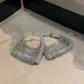 Dettaglio elegante di orecchini a cerchio con nappe in argento e pietre di zircone bianco - Stile Nappina Forma Borsa / Argento