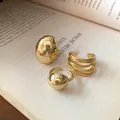 Macro shot of three minimalist gold-toned open rings displayed on an open book. - Geometric Bead Style / Set of 3 / Gold