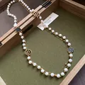 Close-up of vintage French double-layered pearl necklace with camellia charms - White