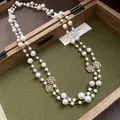 Close-up of vintage French double-layer pearl necklace with rose flower charms - Gold
