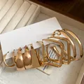 Close-up detail of several pairs of gold geometric hoop earrings on a white card - 10 Pieces Pack / Gold