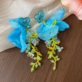 Close-up of sweet blue heart resin earrings with chiffon petals and floral beads. - Heart Flower Tassel Style / Blue, Yellow, Green