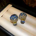 Detailed view of blue and white rhinestone double-sided earrings in a jewelry box - Front-Back Ball Stud Earrings / Blue