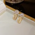 Elegante weiße Perlenohrringe mit gravierten floralen goldenen Anhängern in Box - Perlen Meerjungfrau Blumenanhänger