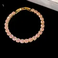 Close-up detail of elegant 18k gold plated tennis bracelet featuring sparkling pink zircons - Gold-Pink