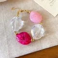 Dettaglio di un braccialetto di perle acriliche marmorizzate rosa e trasparenti - Bracciale