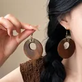 Close-up of New Chinese style wooden hollow circular drop earrings with wire wrap - Style 32 Hook Coffee