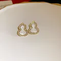 Detailed close-up of gold gourd stud earrings with white enamel and sparkling zircons - Silver Needle Gourd Style / Gold White
