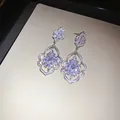 Detailed close-up of sparkling zircon drop earrings with intricate craftsmanship - Petal Style