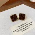 Primo piano di orecchini a lobo quadrati vintage leopardati con cornice dorata - Rombo