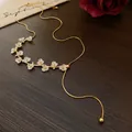 Gros plan d'un collier élégant plaqué or orné de jolies fleurs blanches et de perles - Collier (HN6099) / Or-Blanc