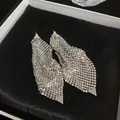 Detailed macro view of silver metallic mesh drop earrings with triangle accents on black velvet. - Triangle Sequin Irregular Style (HE12459) / Silver