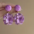 Close-up of vintage purple enamel flower drop earrings held by hand. - Silver Earring Post - Gold - Purple