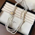 Close-up of elegant multi-strand pearl necklace with a vintage rhinestone rose flower clasp - Multi-Layer Long Style