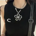 Close-up of a silver sun flower pendant necklace worn with a black gothic-style top. - 31# Sunflower Hollow Style (31#) / Silver-Black