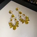 Detailed view of yellow teardrop crystal earrings with elegant hollow geometric design - Yellow