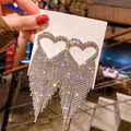Close-up of silver heart-shaped tassel earrings with shimmering rhinestones for a luxe look. - Hollow Heart Tassel Style (22#)