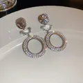 Close-up view of sparkling silver dangle earrings with pave crystals on a white plate - Hammered Round Stud Style (44#)