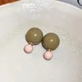 Detail von bonbonfarbenen Doppelperlen-Ohrringen mit Edelstahlstiften auf Keramikteller. - Doppelter Rundball (HE12707) / Braun