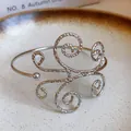 Elegante brazalete de metal martillado plateado con un diseño artístico de remolinos - Estilo Martillado Calado de Volutas (42#) / Plateado