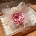 Vista dettagliata di un'elegante pinza per capelli con fiore in tessuto rosa e piume - Molletta per Capelli - Rosa
