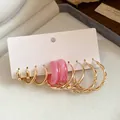 Close-up of a stylish gold-toned hoop earring set with pink marbled resin accents. - Gold and Pink Resin Earring Set (10 Pairs) / 10 Pairs Set / Gold-Pink