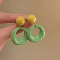 Detail view of retro contrast color earrings featuring a yellow stud and green round ring - 25# Silver Earring Post-Green (Yellow Green Hoop)