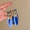 Close-up view of Bohemian blue feather tassel earrings with gold chains and beads. - Light & Dark Blue Feather Hook (HE20859-1)