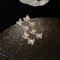 Close-up of elegant butterfly tassel earrings with sparkling cubic zirconia crystals - Gold