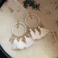 Detailed shot of white tassel hoop earrings with gold beads on a decorative background - White Long Tassel Large Hoop (HE20859-1)