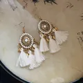 Detail shot of Bohemian retro gold-tone earrings with white tassels and mandala design - Sun Pattern White Tassel (HE20859-1)