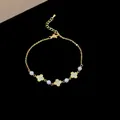 Elegant gold-tone bracelet featuring zircon flower charms and delicate pearls, fashion style. - Triple Flower Beaded Style / Gold