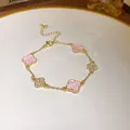Elegant gold clover bracelet featuring pink charms and sparkling crystal accents. - Four-leaf Clover Patchwork / Gold-Pink