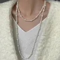Close-up of elegant long pearl necklace layered over a white fuzzy cardigan sweater - Long Style (HN7464) / White Diameter 8mm