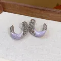 Close-up of wrinkled C-shaped earrings with lavender enamel and silver metallic finish - Silver-Purple