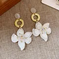 Detail of resin flower drop earrings with golden textured ring and iridescent bead centers - Resin Flower Pendant Style / Gold and White