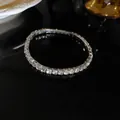 Detailed macro shot of a sparkling silver tennis bracelet with clear square rhinestones - Diamond-encrusted Elastic Claw Chain Bracelet