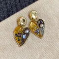 Dettaglio di eleganti orecchini vintage a cuore con intarsi di perle e conchiglie. - Stile Cuore Vintage Letterario / Oro