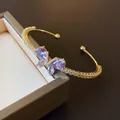 Gros plan d'un élégant bracelet jonc papillon en zircon violet sur un coffret à bijoux - Bracelet jonc / Violet