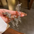 Primo piano di orecchini a farfalla in metallo liquido pieghettato argento - Orecchino a perno e clip integrato / Argento