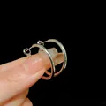 Macro detail view of simple silver-colored metal hoop earrings on a dark background. - Small / Silver