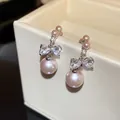 Close-up of elegant bowknot stud earrings with pink pearls and cubic zirconia - Bowknot (HE30985) / Pink