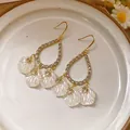 Elegant vintage-style resin flower drop earrings featuring a gold-toned teardrop frame - Style 50 Ear Hook Flower (5942177792985) / White