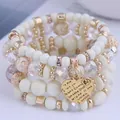 Detailed macro view of elegant white multi-layer beaded bracelet with gold heart charm - 25# Bangle (25#) / Four-Piece Set / Off White