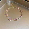 Close-up of gold bracelet with sparkling pink square and marquise cubic zirconia. - Gold Tone Pink