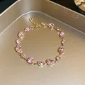 Close-up of sparkling pink pear-cut zircon bracelet on an elegant gold metallic tray - 6# Gold Pink