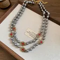 Close-up of vintage double-layer grey pearl necklace with red crystals. - Necklace / Gray