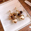 Golden heart dangle earrings with tiger eye style beads presented in a jewelry box context - Heart Charm Style (46#)