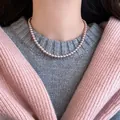 French vintage style light purple pearl choker on a model with pink cardigan and grey sweater - Necklace Style 45 / 4mm Pearl / Pink